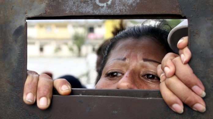 mujer-se-asoma-por-rendija-de-carcel-en-ecuador